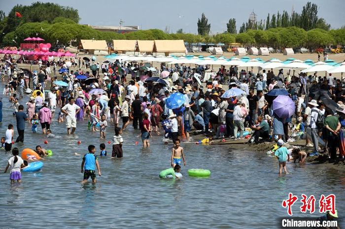 6月22日，来自五湖四海的游客和当地各族群众在和硕县金沙滩景区畅享“海边”清凉。中新网记者 孙亭文 摄